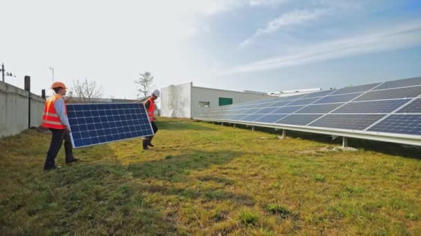 Человек Устанавливает Солнечные Батареи Группа Мультиэтнических Инженеров Размещает Солнечные Панели — стоковое видео