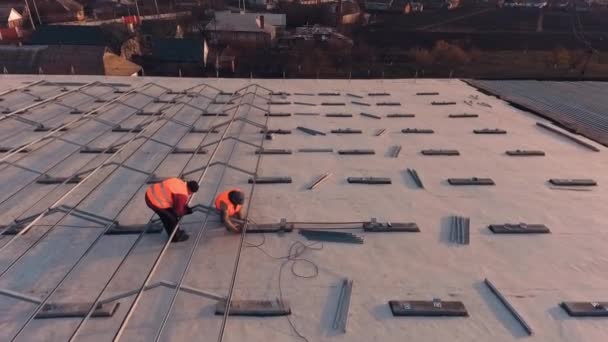 屋根にソーラーパネルを設置する 屋根にソーラーパネルを設置した労働者 — ストック動画
