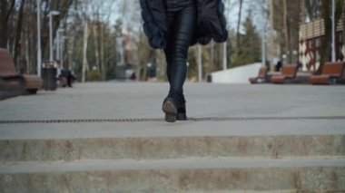 Parkta yürüyen güzel bir kadın. Açık havada poz veren günlük elbiseli bir kadın.