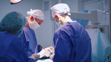 Modern klinikte ameliyat. Ameliyathanede ameliyat ekipmanlarıyla bir grup cerrah.