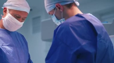 Hastanede cerrahlar hastayı ameliyat ediyor. Ameliyat ortamında cerrahi ekip