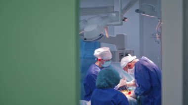 Cerrahlar ameliyat yapıyor. Cerrah ve asistanları hastanede ameliyat yapıyorlar.