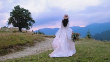 Dağ tepesinde gelin. Dağ tepelerinde yürüyen güzel genç gelin