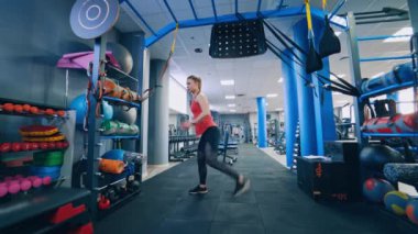 Spor salonunda çalışan güzel bir kadın. Spor salonunda egzersiz yapan sağlıklı genç sporcular.