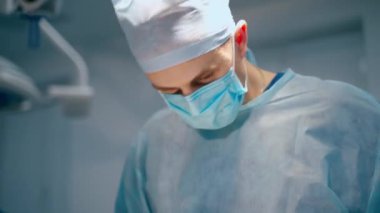 Cerrah canlı çekim yapıyor. Modern ameliyathanede yakışıklı orta yaşlı bir doktor.