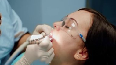 Doktor hasta dişlerini tedavi eder. Dişçiyle stomatoloji kliniğinde çekici genç bir kadın.