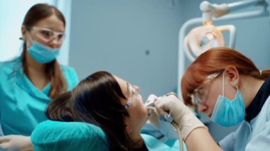 Kadın dişçiye gidiyor. Diş hekimliğinde kadın hasta muayenesi sırasında diş hekimi.