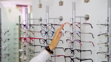 Optik dükkanındaki kadın. Vitrindeki bardakları çeken kadın ellerini kapat.