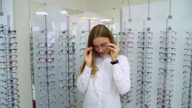 Optik mağazasındaki kadın. Optik mağazasında gözlük seçen mutlu kadın.
