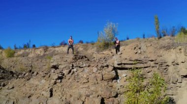 Sporcular dambıllarıyla egzersiz yapıyor. Dambılı genç bir erkek sporcu.