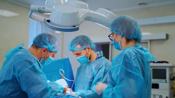 Médicos Especialistas Sala Cirurgia Moderna Médicos Realizar Uma Cirurgia Olhando — Vídeo de Stock