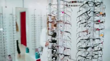 Optometristteki kadın. Optik mağazada gözlüklü genç bir kadın.