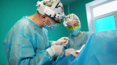 Cerrah ve asistan iş başında. Profesyonel doktorlar ameliyathanede ameliyat yapıyorlar.