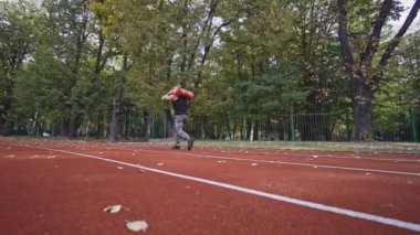 Spor yapan bir adam. Yarış pistinde antrenman yapan bir adamın arka görünüşü