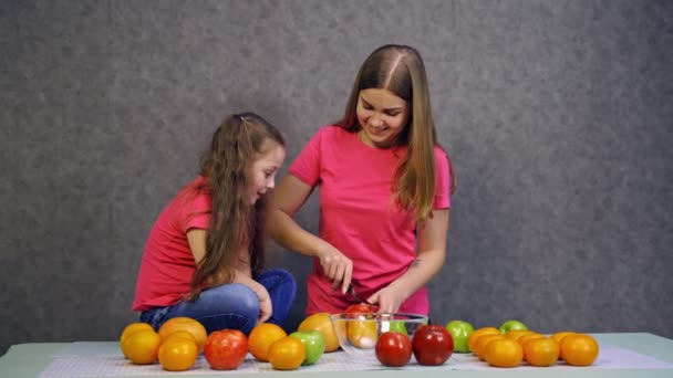 Frau Schneidet Früchte Auf Dem Tisch Junge Frau Mit Tochter — Stockvideo