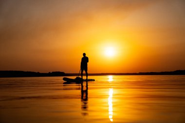 Sörf tahtasının üzerinde duran bir insan.