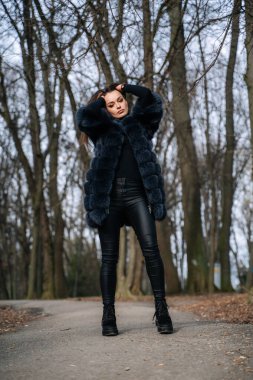 Kürklü bir kadın fotoğraf için poz veriyor.