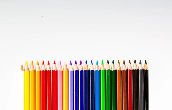A group of colored pencils lined up in a row