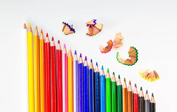 A rainbow of colored pencils with a butterfly on top
