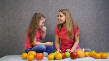 Kızıyla meyve yiyen bir kadın. Kızıyla portakal yiyen mutlu bir kadın.