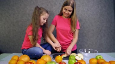Meyve salatası yapan kız. Kızlar salata için meyve dilimledi.