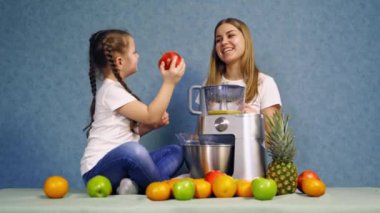 Meyve püresi yapan kadın. Masanın yanında meyve ve blender ile gülümseyen güzel kız.