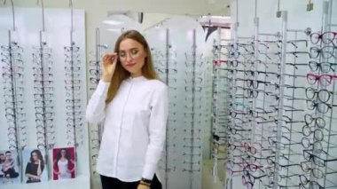 Gözlükçüdeki kadın. Gözlük takan kadın gözlükçüden almak istiyor.
