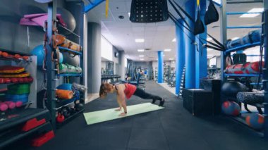 Spor salonunda kadın egzersizi yapıyor. Beden dersinde hasırda egzersiz yapan kadın.