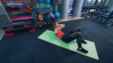 Spor paspasındaki jimnastik kadını. Spor salonunda çalışan genç bir kadın.