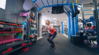 Spor salonundaki aktif kız. Güzel, kaslı, fit bir kadın spor salonunda egzersiz yapıyor.