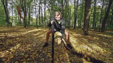 Savaş ipleri olan bir adam. Parkta halatlarla egzersiz yapan güçlü bir adam.