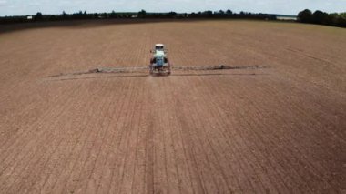 Sahada çalışan çekici araçlar. Tarlada çalışırken traktörün hava görüntüleri.