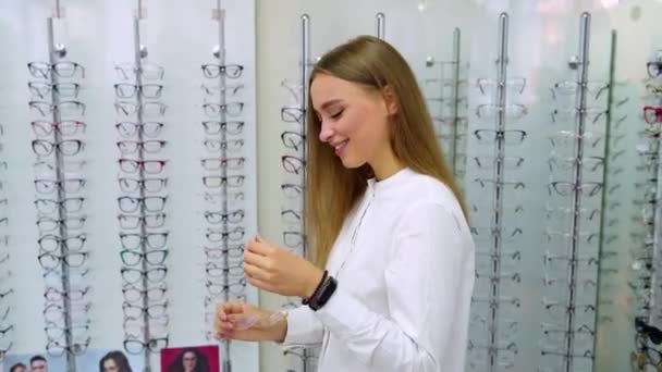 Flicka Som Väljer Glasögon Kvinna Optisk Butik Väljer Glasögon — Stockvideo