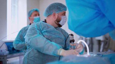 Doktor ameliyat yapıyor. Ameliyat ekibi ameliyathanede.