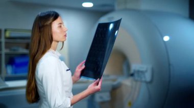 Doktor MRI görüntüsünü inceliyor. Kadın doktor röntgen sonuçlarına bakıyor.