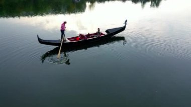 Gondollu şehir nehri. Şehir nehrinde gondolla gezen turistler