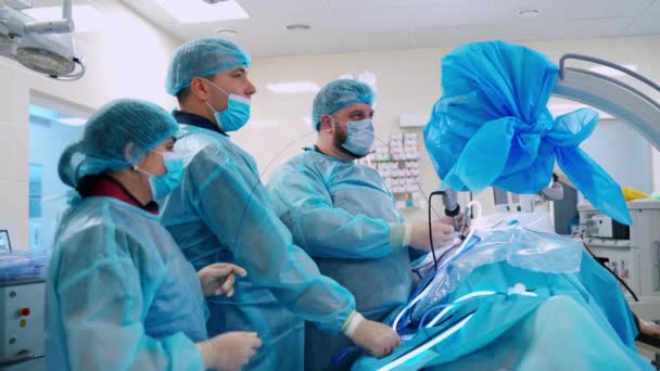 オペレーティングルームで撮影 病院で手術をしている外科医のグループ — ストック動画