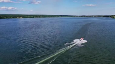 Tekne nehirde yüzüyor. Nehirde yüzen küçük motorlu teknenin hava aracı görüntüsü