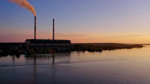河川付近の航空産業について 日没時に川近くの工場の空中ドローンビュー — ストック動画