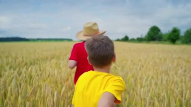 Buğday tarlasında oynayan çocuklar. Kardeşler buğday tarlasını geçiyor.