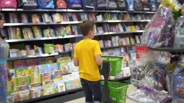 Мальчик Выбирает Школьные Принадлежности Портрет Школьника Делающего Покупки Супермаркете — стоковое видео