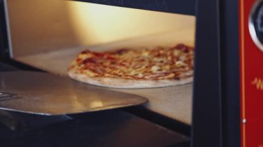 Geleneksel İtalyan pizzasını hazırlıyorum. Restoran şefi geleneksel restoranda fırından pizza alıyor.