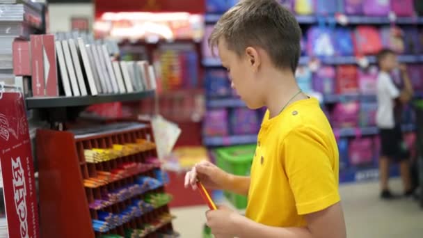 文房具店にいるかわいい少年 文房具店で学校用品を購入する — ストック動画