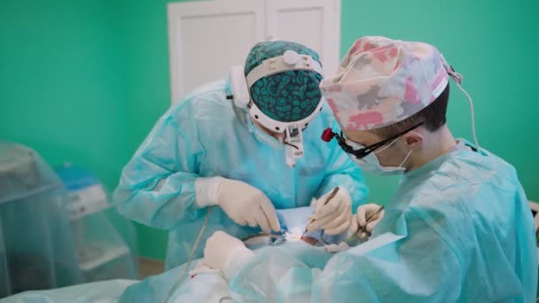 オペレーティングルームで外科医 クリニックで手術を行う専門外科医チーム — ストック動画