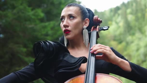 女孩在室外表演音乐 音乐家在大提琴上演奏山地音乐 — 图库视频影像
