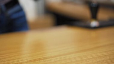 Tahta masada bir fincan kahve. Barista, kafede tüketiciye kahve satıyor.