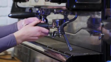 Barista kafede kahve makinesi kullanıyor. Genç barista modern kahve dükkanında otomatik makinede kahve hazırlıyor.