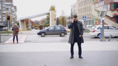 Dışarıda cep telefonu olan bir iş adamı. Genç işadamı sokakta cep telefonuyla konuşuyor.
