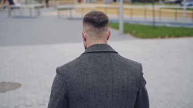 Koronavirüs kapanışı sırasındaki adam. Koruma maskesi takan genç adam, tecrit açıldıktan sonra şehre giriyor.