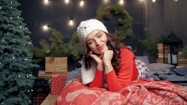 Genç bir kadın Noel 'de dinleniyor. Kırmızılı zarif bayan Noel arkaplanında